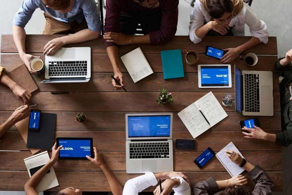 Business team working together around a table with laptops