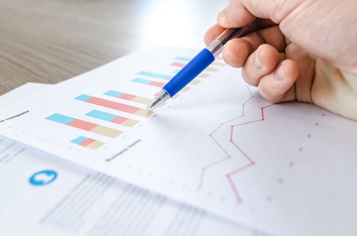 Business owner reviewing website costs and charts on paper