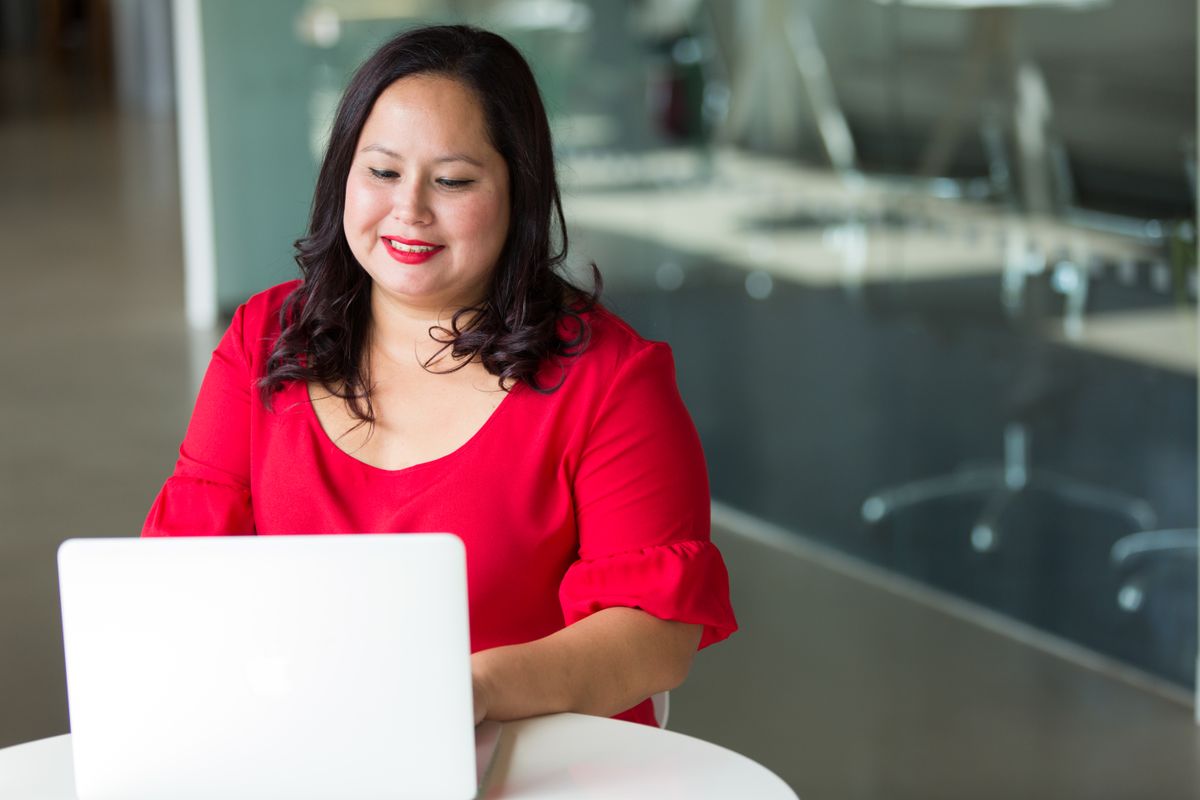 Smiling woman working on her laptop in a bright modern office